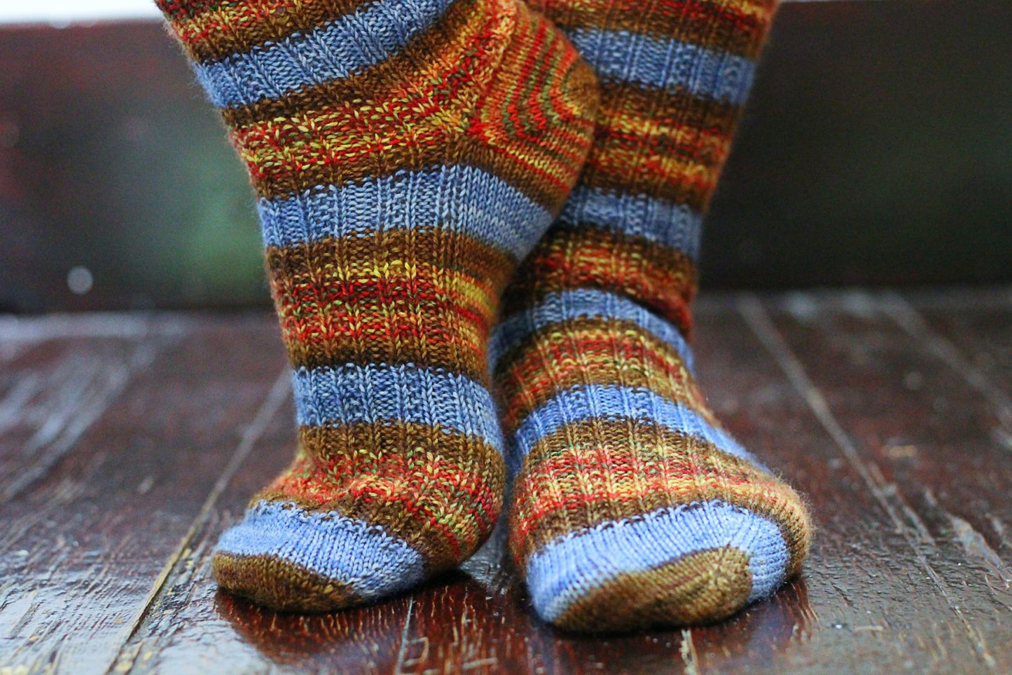  self-striping sock yarn being worn on wooden floor